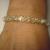 Swarovski crystals woven with gold lined glass beads. It sort of twists, but lays nicely on the wrist.  $30.00