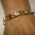 Soft bangle style bracelet with gold plated tube beads, accent beads, and 3 large clear Chaton crystals. $25.00
