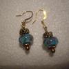 Turquoise colored glass bead earrings with antique gold flower patterned spacer beads on gold wires. There are sweet little flowers inside the perimeter of the beads too.  15.00